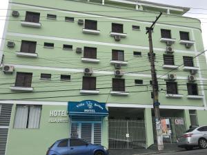 毛阿Hotel Villa Brites的绿色建筑,前面有酒店标志