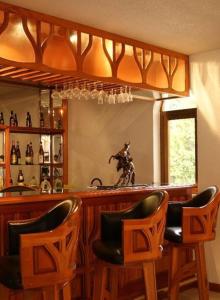 瓦斯卡坎波精髓精品酒店的酒吧配有两把椅子和带镜子的吧台