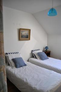 吉维尼Cottage Les Quatre Saisons的两张睡床彼此相邻,位于一个房间里