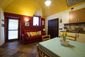 阿罗纳Casa Corte Alla Rocca的客厅配有桌子和红色沙发