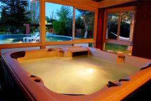查克拉斯德科里亚罗伯斯德贝萨烈酒店的一个带游泳池的房间的大浴缸