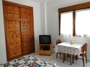 阿桂拉斯Los Geraneos的一间设有桌子、电视和门的房间