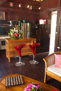 帕佩托艾Robinson's Cove Villas - Deluxe Wallis Villa的厨房配有红色的椅子和一张桌子及柜台