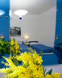 罗马White Vatican的一间卧室配有床、镜子和黄色的鲜花