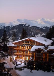 谷雪维尔Snow Lodge Hotel Courchevel 1850的雪覆盖的山地的滑雪小屋