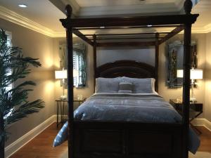 YoungsvilleLouisiana Cajun Mansion的一间卧室配有一张带蓝色枕头的天蓬床