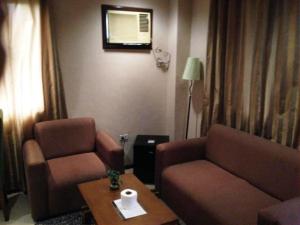 安吉利斯藏珠酒店（杰那斯奢华套房）的客厅配有沙发、椅子和桌子