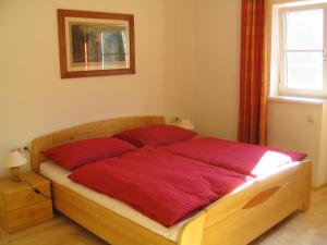 哈尔施塔特萨里斯特因旅馆的一间卧室配有一张带红色床单的床和一扇窗户。