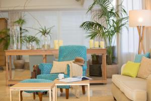 帕尔马海滩Universal Hotel Neptuno - Adults Only的客厅配有椅子、沙发和桌子