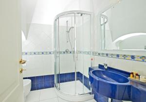 阿纳卡普里圣米歇尔酒店的带淋浴和蓝色浴缸的浴室
