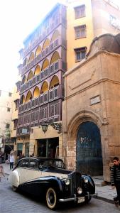 开罗Le Riad Hotel de Charme的停在大楼前的旧车