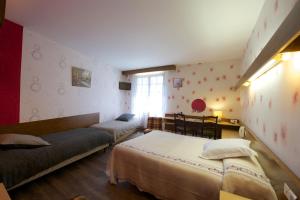 Arudy罗杰斯法国酒店的一间卧室设有两张床和窗户。