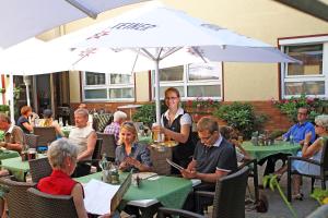 Rödental戈洛斯彻布朗酒店&旅社的一群坐在餐厅桌子上的人