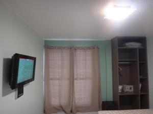马瑙斯Ajuricaba Suites 1的卧室配有壁挂式平面电视。