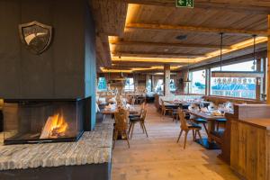 基茨比厄尔BichlAlm Berggasthof的一间带壁炉和桌椅的餐厅
