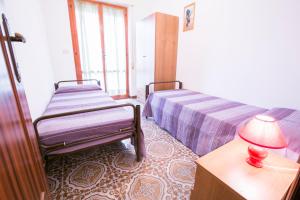 皮内托Gemma 3 Pineto Vacanza的一间卧室配有两张床和一张带台灯的桌子
