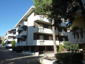 皮内托Gemma 3 Pineto Vacanza的前面有一棵树的白色公寓大楼