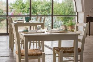 奥斯图尼Masseria Palombara Grande的桌子和椅子,上面有盘子和杯子