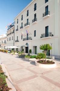 圣凯撒利亚温泉地中海大酒店的一座白色的大建筑,有两面美国国旗