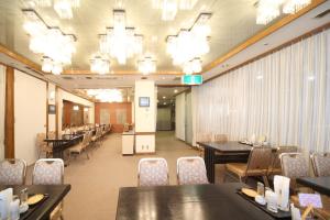 八户市八户威阿雷二号酒店的用餐室配有桌椅和吊灯。