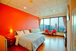 高雄空中城都會商旅的一间卧室设有一张床和红色的墙壁