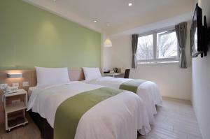 台中市叶绿宿旅馆 - 逢甲馆的一间卧室设有两张床和窗户。