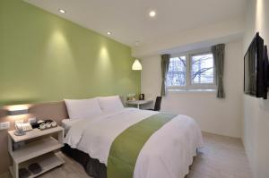 台中市叶绿宿旅馆 - 逢甲馆的一间卧室设有一张大床和一个窗户。