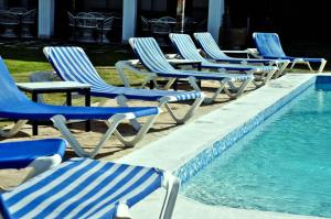 蓬塔卡纳Hotel Marimba Punta Cana的游泳池旁的一排草坪椅