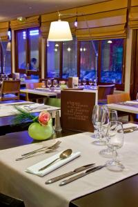 尚布雷莱图尔基里亚德图尔苏德尚布莱酒店的餐厅的一张桌子,上面有白色的桌布