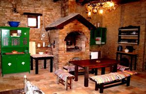 Kneževi VinogradiGuest House Stara Baranja的厨房配有砖炉和桌椅