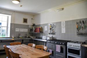 英格尔顿Ingleton Hostel的厨房配有桌子和炉灶。 顶部烤箱