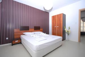 阳光海滩精品套房彩虹4酒店的卧室配有白色的床和木墙