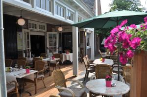 Den Dungen波尔古森斯酒店的一个带桌椅和遮阳伞的庭院