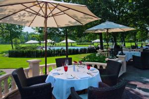 奥特马瑟姆帷幕赛尔公园酒店的餐厅里一张桌子,上面放着酒杯和遮阳伞