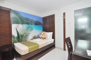 塔比拉兰塞萨尔广场717号酒店的一间卧室配有一张带海滩绘画的床