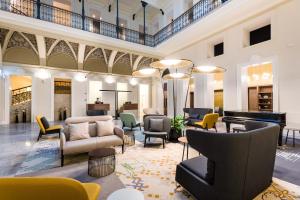 布达佩斯Hotel Moments Budapest by Continental Group的一个带椅子和钢琴的大型大堂