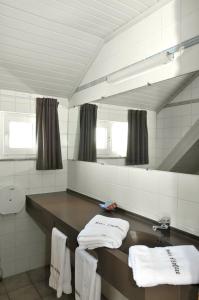 泽伊恩克尔克多福斯特餐厅酒店的浴室配有盥洗盆、镜子和毛巾