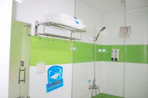 垫江7天连锁酒店重庆垫江长安文化新城店的浴室设有绿色和白色的墙壁,配有淋浴。