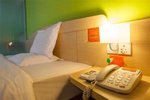 垫江7天连锁酒店重庆垫江长安文化新城店的酒店客房配有电话和床。