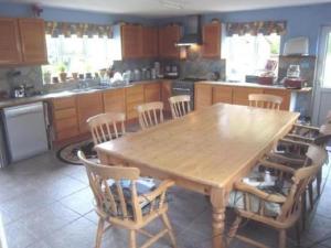 诺里奇Hethersett Lodge的厨房配有木桌和椅子
