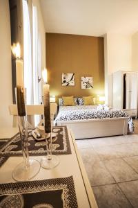 特拉尼B&B Germinario的一间卧室配有一张床和一张带两个蜡烛的桌子。