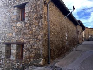 BojarCasa Rural El Boixar - El Mirador的一座古老的石头建筑,旁边是鸟