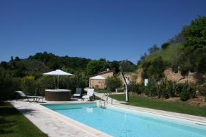 蒙特普齐亚诺Casa Cervognano的一个带桌子和遮阳伞的游泳池