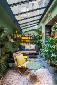 巴黎巴黎COQ酒店的一间配有沙发、桌子和植物的房间