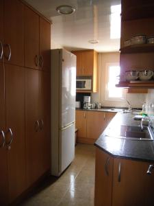 略夫雷加特河畔奥斯皮塔莱特阿蒂科索雷亚德公寓的厨房配有白色冰箱和木制橱柜。