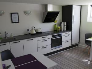伊凯斯特Ikast Bed & Kitchen的厨房配有白色橱柜和炉灶烤箱。