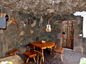 弗龙特拉Casa Guinea的墙上有桌子和吉他的房间