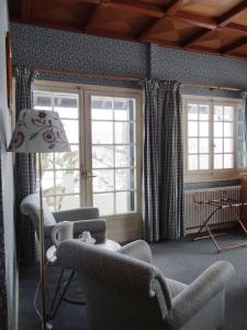 埃沙内韦奥贝奇酒店的客厅配有椅子和一盏灯,设有窗户