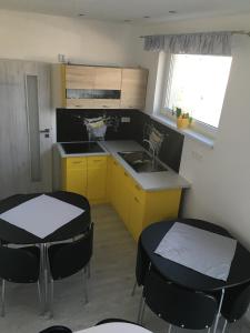 BudimírMini Motel的厨房配有2张桌子、水槽和黄色橱柜