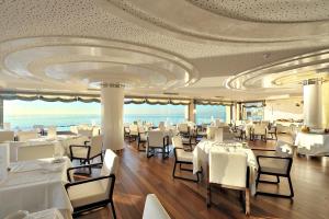 贝纳尔马德纳Vincci Selección Aleysa的餐厅设有白色的桌椅和天花板